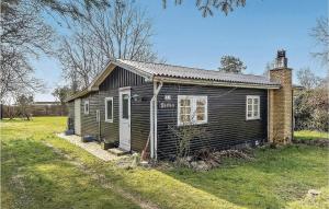 a small house in a field next to a house at Nice Home In Sydals With Wifi in Østerby +7 photos