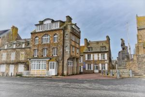 a large brick building with a statue in front of it at Maison Henri Chardon in Barfleur