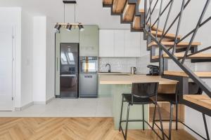 kuchnia z białymi szafkami i schodami w obiekcie Spacious Family Apartment with FREE GARAGE by Renters we Wrocławiu
