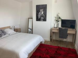 a bedroom with a bed and a desk with a tv at L havre de paix in Avelin