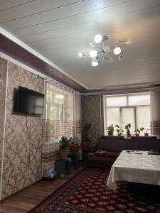 un soggiorno con tavolo e TV a parete di Jyrgal jashoo guest house 