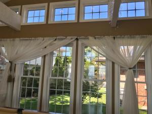 a window with white curtains in a room at Happy vacation home by Erie lake in Kingsville