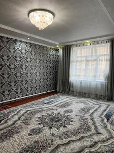 una camera con un grande tappeto e un lampadario a braccio di Jyrgal jashoo guest house 