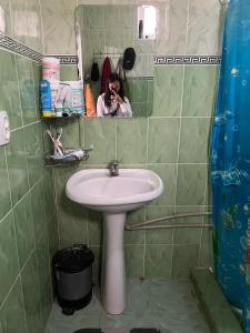 una persona che scatta una foto di un lavandino in bagno di Jyrgal jashoo guest house 