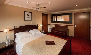 a bedroom with a bed with a book on it at Hollies Hotel in Martock