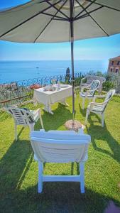 tavolo e sedie con ombrellone e oceano di Villa Mortola a Camogli