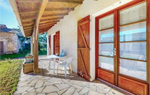 eine Tür zu einer Terrasse mit einem Tisch und einem Stuhl in der Unterkunft Nice Home In La Grimaudire With House A Panoramic View 