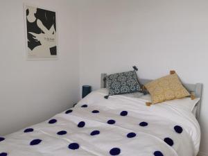 a white bed with blue polka dots on it at Relax and enjoy the sea view in Kent