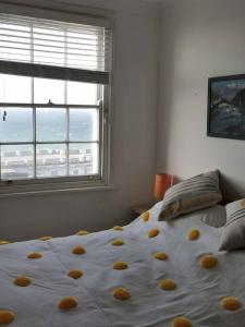 uma cama com flores amarelas num quarto em Relax and enjoy the sea view em Kent