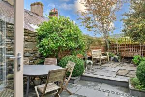 a patio with a table and chairs in a yard at Finest Retreats - Hen Dafarn in Conwy