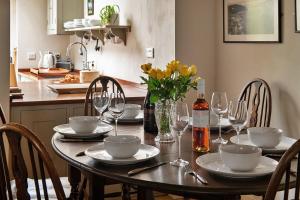 a dining room table with plates and wine glasses at Finest Retreats - Hen Dafarn in Conwy