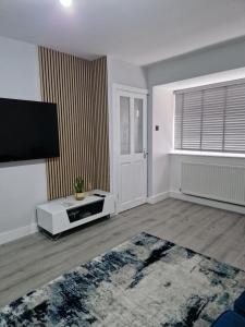 an empty living room with a flat screen tv at Stylish 2 bed home- short walk to Tottenham Stadium/Stations in London