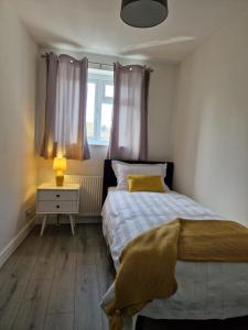 Habitación pequeña con cama y ventana en Stylish 2 bed home- short walk to Tottenham Stadium/Stations, en Londres