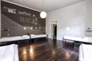 a room with two beds and a wall with a poster at Sophie's Hostel in Prague