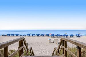 a beach with chairs and umbrellas and the ocean at Majestic Beach Towers 2013 in Panama City Beach