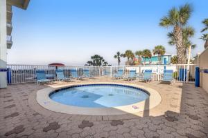 a small swimming pool with chairs and a fence at Majestic Beach Towers 2013 in Panama City Beach