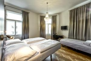 a bedroom with two beds and a chandelier at Sophie's Hostel in Prague