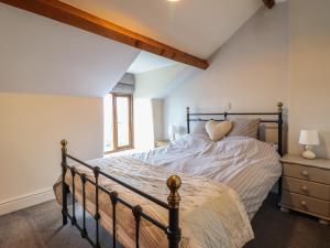 a bedroom with a large bed and a window at 2 Ty Capel in Corwen