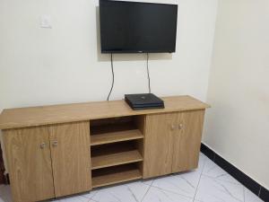 a wooden cabinet with a television on top of it at Safari Lake view apartments, Muyenga in Kampala