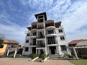 a tall white building with a sky in the background at Safari Lake view apartments, Muyenga in Kampala