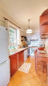 a kitchen with a white refrigerator and a table at Villa Mortola in Camogli