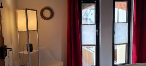um quarto com uma janela com uma cadeira e um candeeiro em Ferienappartements im Speicherwerk em Quedlinburg