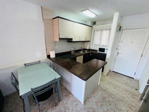 a kitchen with a counter and a table in it at Las Vistas Beach Los Cristianos 2 Swimming Pools in Los Cristianos