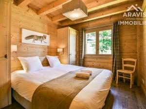 a bedroom with a large bed in a wooden cabin at Chalet Le Grand-Bornand, 5 pièces, 8 personnes - FR-1-391-8 in Le Grand-Bornand