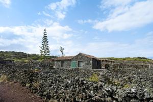 ein altes Steinhaus auf einem Felsen in der Unterkunft Adega Maciel in Lajido