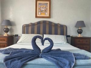 Dos cisnes forman un corazón en una cama en B&B VILLINO MARGHERITA, en Roma