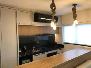 a kitchen with a counter and a stove top oven at Flat 403 - Central - Edifício Home Business in Pomerode