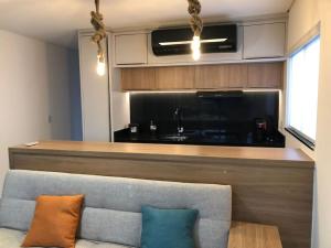a living room with a couch and a kitchen at Flat 403 - Central - Edifício Home Business in Pomerode