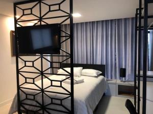 ポメロデにあるLindo Flat Central - Home Businessのベッドルーム1室(ベッド1台、上部にテレビ付)