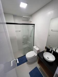 a bathroom with a shower and a toilet and a sink at Lindo Flat Central - Home Business in Pomerode