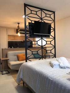 Habitación con cama, TV y sofá. en Lindo Flat Central - Home Business en Pomerode