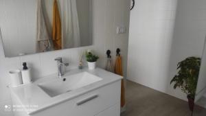 a bathroom with a white sink and a mirror at Casa Tia Pilar in Algodonales +15 photos