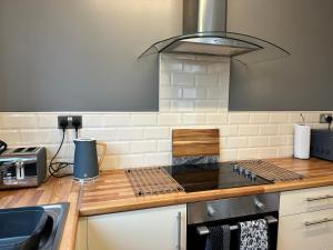 a kitchen with a counter top with a stove at Spacious 3 bed house in Wombwell in Wombwell