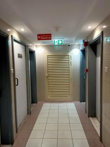 un couloir avec des portes et un panneau sur le mur dans l'établissement Rovers Boys Hostel Dubai Near Gold Souq Metro, à Dubaï