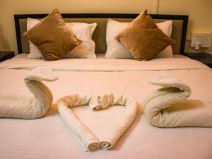 a bed with towels in the shape of a heart at snooze inn jodhpur in Jodhpur