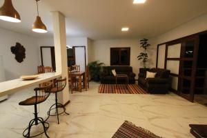 a living room with a kitchen and a living room with a bar at Villa Botanic Garden in Itacaré