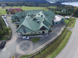 a large house with a green roof on a street at Centrum Wypoczynku i Rehabilitacji Umina in Czorsztyn