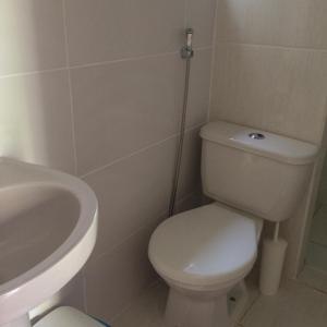 a bathroom with a white toilet and a sink at Pousada Flor de Debora in Alto Paraíso de Goiás