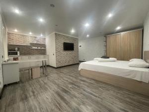a large room with a bed and a kitchen at Квартира бизнес-класса с белым постельным кафе Маринад (Назарбаева/Интернaциональная) in Petropavlovsk +3 photos