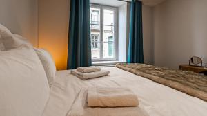 een slaapkamer met een bed met twee handdoeken erop bij Aux Fleurs de Darcy Confort Centre Ville in Dijon