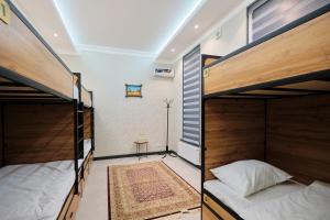 a room with two bunk beds and a table at Samarkand Hostel in Samarkand