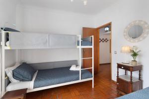 Cette chambre comprend 2 lits superposés et une table. dans l'établissement Retro Beach House Moledo, à Moledo
