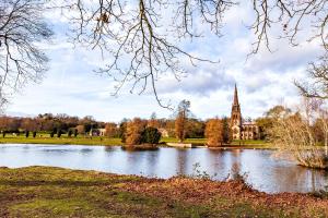 a view of a building with a pond and a church at Apartment 10, Plants Yard, Bridge Street. in Worksop