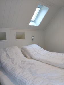 una camera bianca con un grande letto e un lucernario di Southern bliss - Sørlandsidyll a Feda