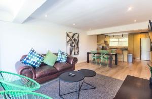 a living room with a couch and a table at Mouille Point Apartments in Cape Town