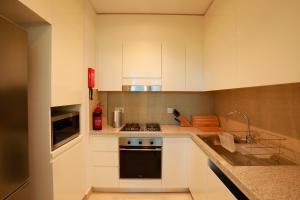 a kitchen with white cabinets and a stove top oven at Stunning Apartment with Direct access to Dubai Mall in Dubai